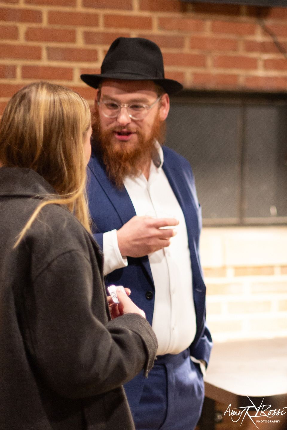 Rabbi Nossen in conversation with a guest at the formal