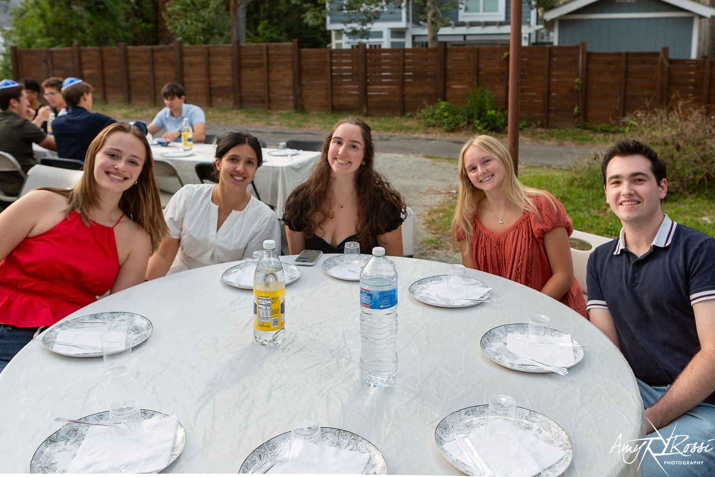 Friends seated together at a round Shabbat table