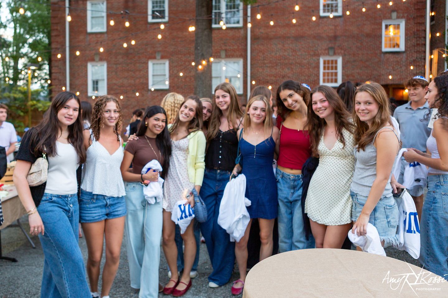 A big group of friends together at golden hour outside the Fleishman House